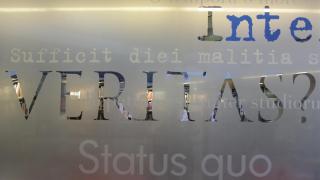 Glass wall with the latin text veritas.